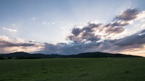 Time lapse - purple clouds speed over mountains at sunset with rays of sunlight Stock Footage 65028223