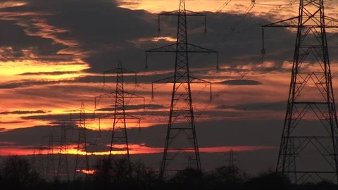 Time lapse of pylons in the burning evening sun as clouds move fast Видео 70715794