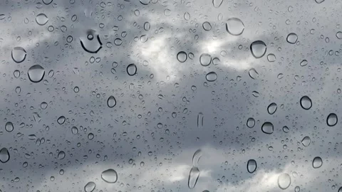 Time lapse of rain clods behind a glass panel with drops Stock Footage 276319143