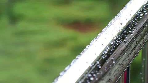 Time lapse rain drops on iron tube, green field background  Stock Footage 64284315