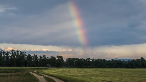 Time lapse rainbow over grass field after summer storm Stock Footage 120990366