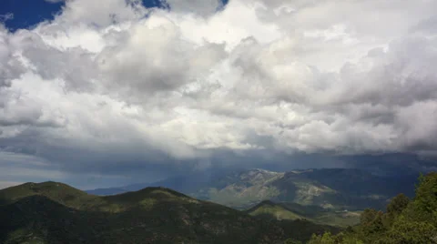 Time lapse of rainy clouds moving fast above green hills Stock Footage 38242340