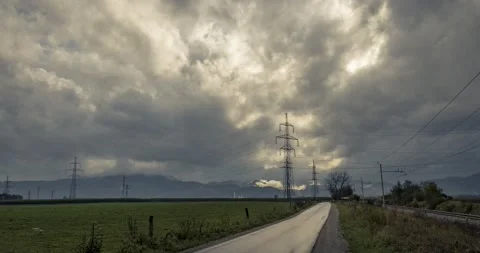 Time lapse of rainy clouds moving fast over farming field and countryside road Stock Footage 140542701