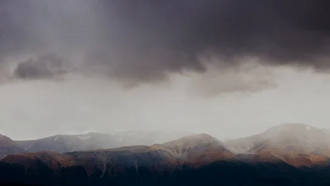 Time-lapse rapidly changing weather in the mountains. Clouds run and snow Stock Footage 100760217