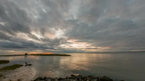 Time lapse of rapidly floating clouds over a river at sunset hour Stock Footage 137932307
