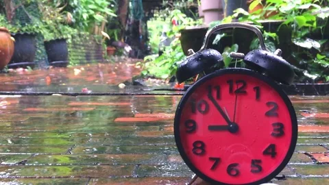 Time lapse of a red alarm Clock speeding up on rainy day Stock Footage 76455146