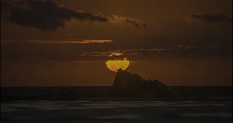 Time Lapse of a Red Full Moon Rising over Beach Rocks 스톡 동영상 143508785