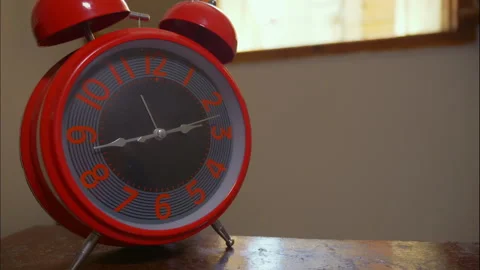 Time-Lapse of a Red Retro Alarm Clock by an Open Window Stock Footage 337832227