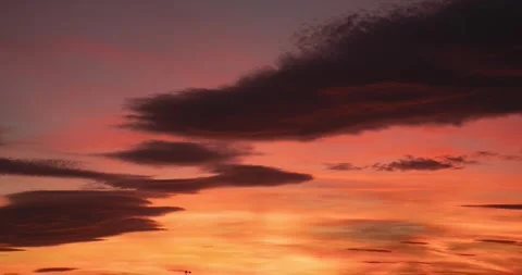 Time lapse of a reddish sky with moving clouds at dusk until night falls Stock Footage 256774299