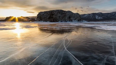 Time Lapse. Reflection of the setting sun in the transparent ice of Lake Baikal. Stock Footage 73359249