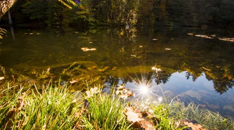 Time lapse - Reflection of the sun at a small lake 스톡 동영상 58655886