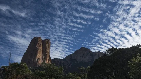 Time lapse of rippled clouds moving over a rock monolith Stock Footage 82528372