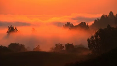 Time-lapse. The rising sun colors the swirling mist in scarlet tones 스톡 동영상 105662995