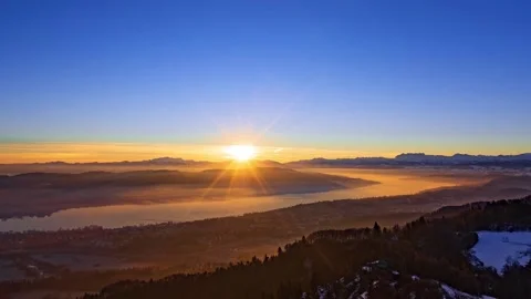 Time-lapse, rising sun, Lake Zurich at sunrise and small town by shore in winter Stock Footage