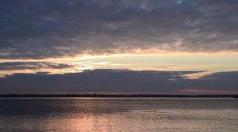Time lapse with rising sun shining through clouds over lake Stock Footage 68325818