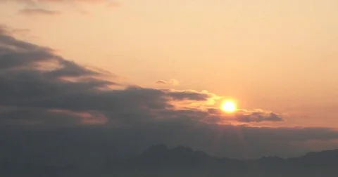 Time lapse of rising sun through dark clouds Stock Footage 74003413