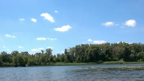 Time lapse of river flow and white clouds floating in the blue sky. Video stock 135757362