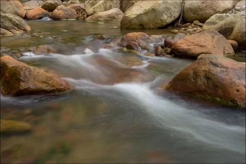 Time lapse of river rushing through orange rocks Stockbeeldmateriaal 91124310