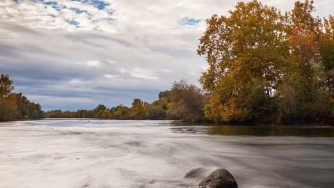 Time Lapse of River Surrounded By Trees With Fall Colors Stock Footage 104015833