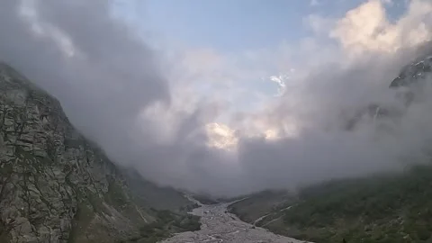 Time-lapse of rolling clouds covering a mountain landscape Stock Footage 337302329