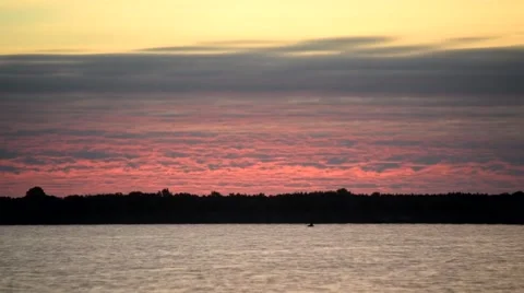 Time lapse of rose colorful clouds at dawn over a river with dark tree Video stock 67601876