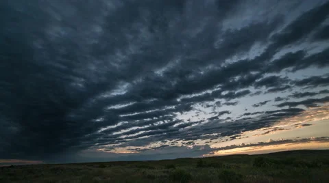 Time lapse - rows of clouds pass towards rising sun at dawn Stock Footage 65023875