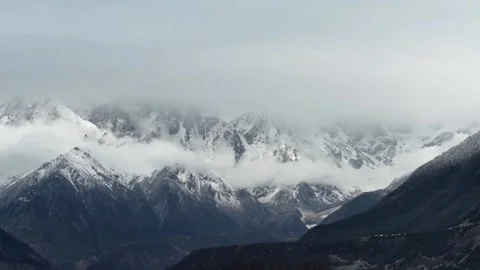 Time-lapse of Rushing Sea of Clouds Over Snow Mountains Видео 332383173
