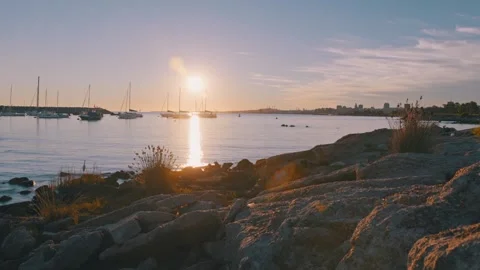 Time lapse of sailboat harbor at sunset with rocky shore Stock Footage 345812420