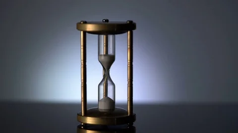 Time Lapse of Sand Flowing Through vintage metal hourglass on grey background Video stock 75959074