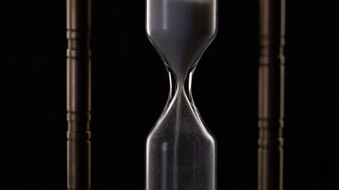 Time Lapse of Sand Flowing Through vintage metal hourglass on black background Stock Footage 75966253