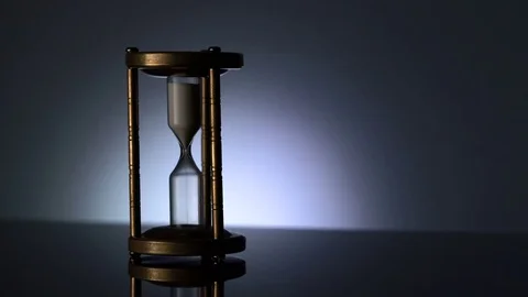 Time Lapse of Sand Flowing Through vintage metal hourglass on grey background Stock Footage 75966755