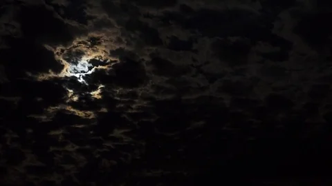 Time lapse of a scary looking moon obscured by dark clouds at night Stock Footage