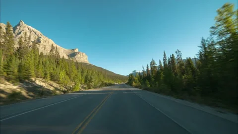 Time Lapse Scenic View Of Snowy Mountains Against Clear Sky, Road Amidst Green Stock Footage 160314577