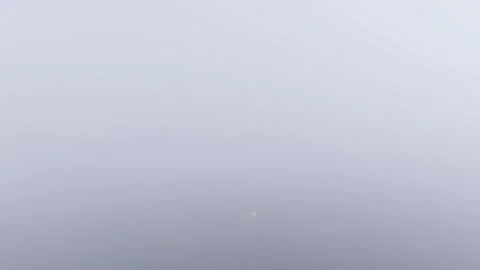 A time-lapse sequence showing thick coastal fog gradually clearing to reveal a Stock Footage 346701966