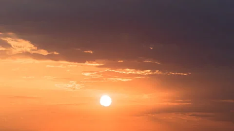 Time lapse of setting huge sun through the moving clouds in rainy orange sky Stock-Footage 139614367