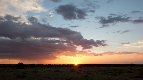 Time lapse of the setting sun illuminating colorful sunset clouds Stock Footage 93807936