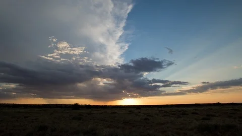Time lapse of the setting sun sending light rays from behind approaching clouds Stock Footage 93809676