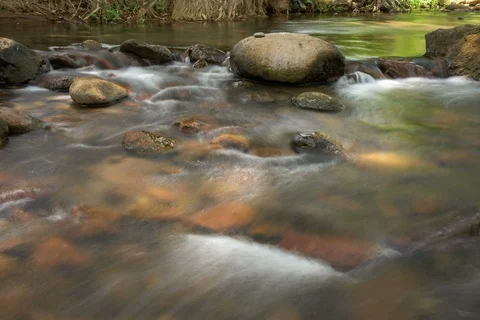 Time lapse of shallow, smooth flowing river Stockbeeldmateriaal 91117553