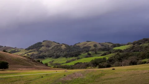Time Lapse: Sheets of rain and hail as storm clouds move over hilly landscape Stock Footage 234330822