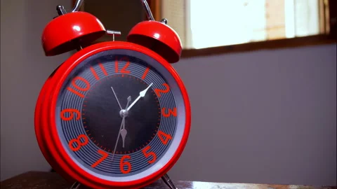 Time-Lapse of a Shiny Red Retro Alarm Clock by an Open Window Stock Footage 337902113