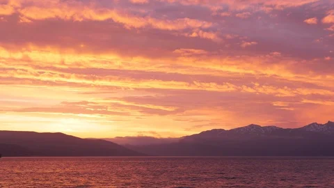 Time lapse of ship sailing under midnight sun orange glow on clouds above Tromso 스톡 동영상 113732856