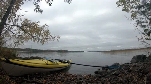 Time lapse shot of clouds moving over lake with kayak on the shore Stock Footage 158075229
