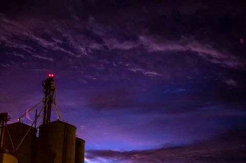 Time lapse shot of clouds in night sky over silos Stock Footage 75185206