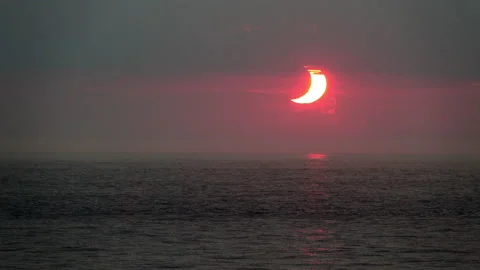 Time-lapse shot of crescent-shaped sun during a sunrise partial solar Stock Footage 155669781