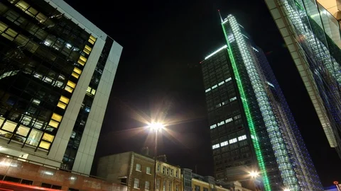 Time lapse shot facing up toward illuminated building within city, night Stock Footage 99170834