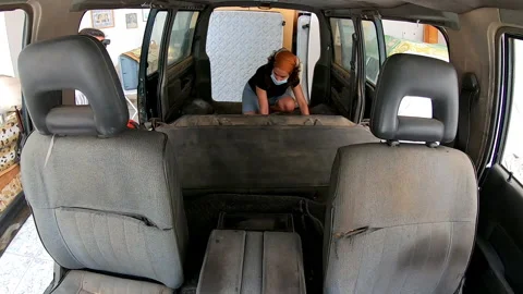 Time lapse shot from inside the car of two people removing seats from a van Stock Footage 172081418