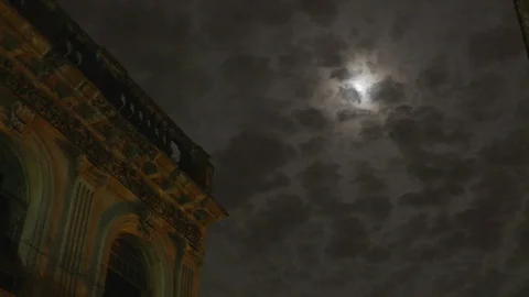 Time Lapse shot of night cloudy sky with shining moon and building on side, Cuba Stock Footage 141667443