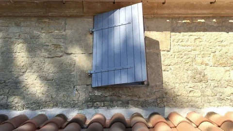 Time lapse shot of an old window shutter with shadows moving across as time pass Stock Footage 79608867