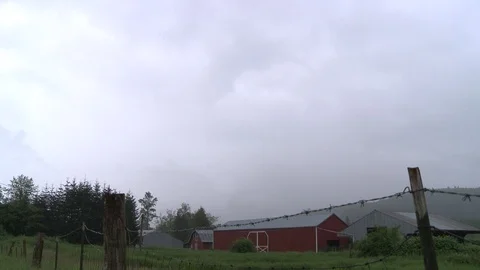 Time-lapse shot of rainstorm passing over farm in Oso, WA. Video stock 86756588
