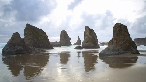 Time lapse shot of waves splashing on stack rocks at Bandon Beach against cloudy Stock Footage 130070035